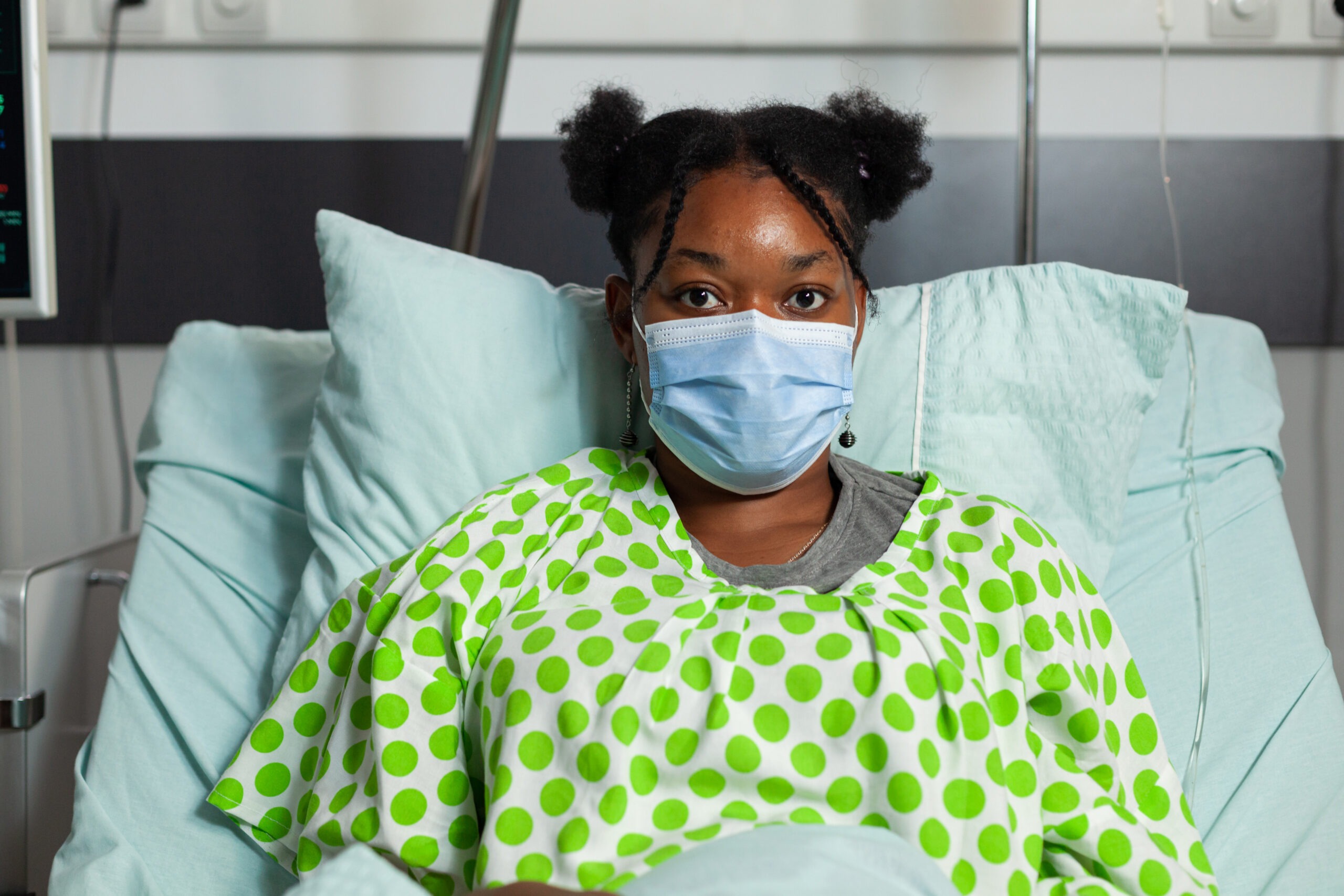 portrait of sick young patient lying in bed during medical appointment